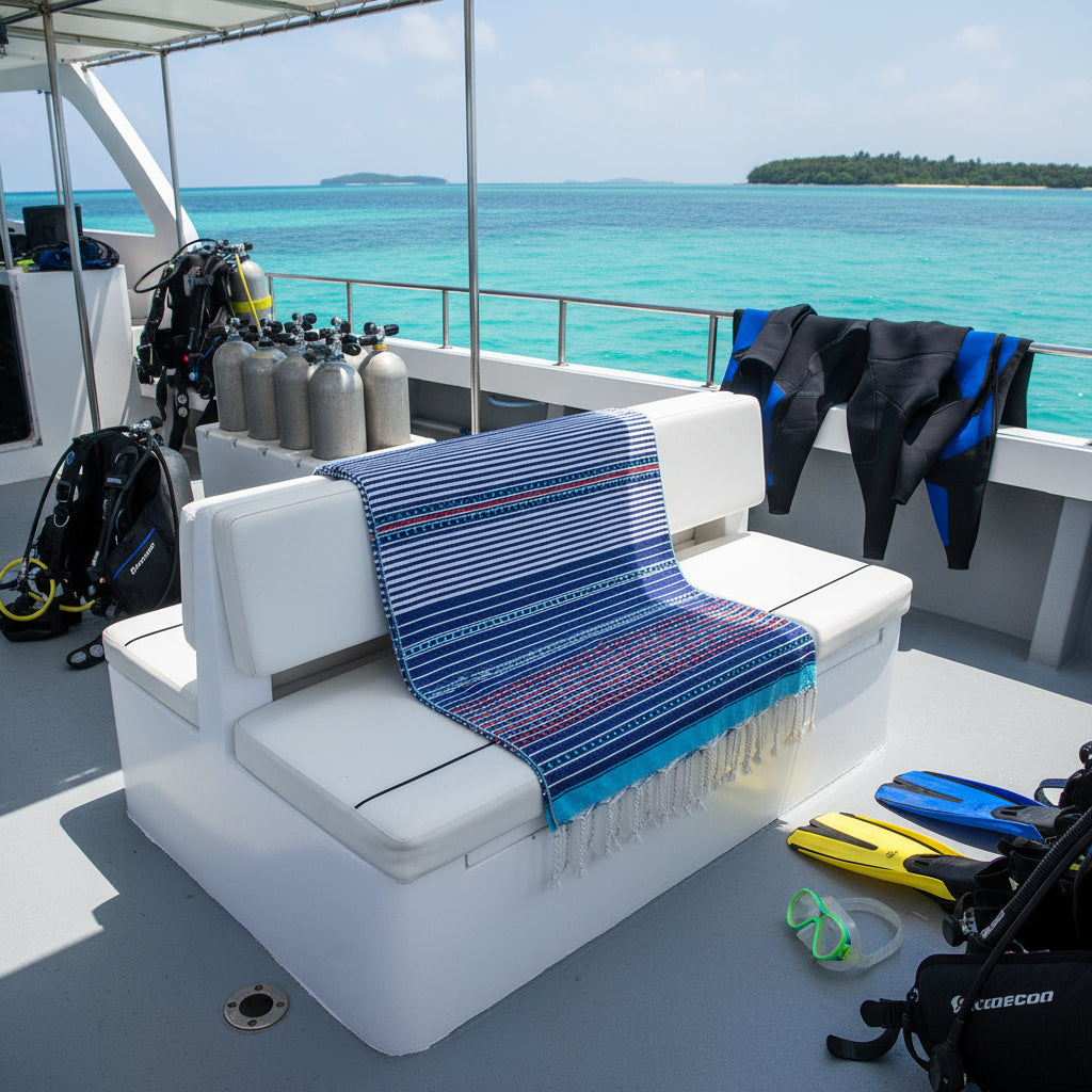 White bench with a blue towel on a boat deck with ocean and islands in the background
